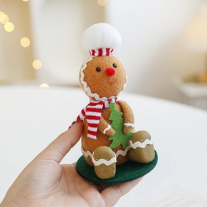 Gingerbread man felt ornament with chef hat and Christmas tree on a warm bokeh background