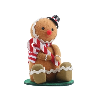 Gingerbread man ornament with red scarf and candy cane on green base for Xmas decor