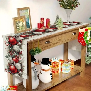 Detail of Christmas table runner with red berries and green pine needles on white linen