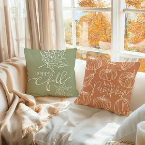 Autumn linen pillow covers set featuring painted pumpkins and maple leaves on a sofa