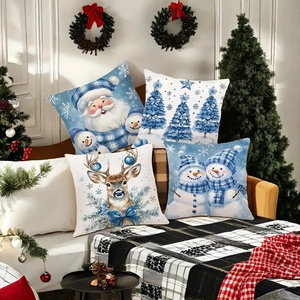 Set of four blue Christmas throw pillow covers with snowman and reindeer on cozy sofa