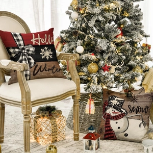Detail view of linen Christmas pillow covers featuring snowman and winter motifs on a chair
