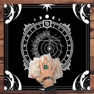 Detail of black tarot altar cloth with white mandala moon phase and zodiac chart