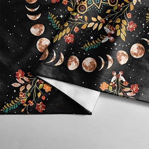 Close-up of tarot tablecloth showing moon phases and floral print with stitched edges