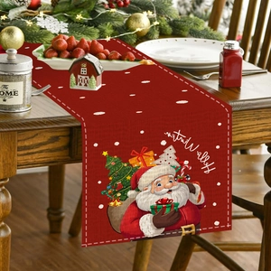 Detail of red linen Christmas table runner featuring Santa Claus and snowflake prints