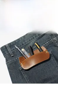 Brown leather tool pouch organizer tucked into a denim jeans pocket for portability
