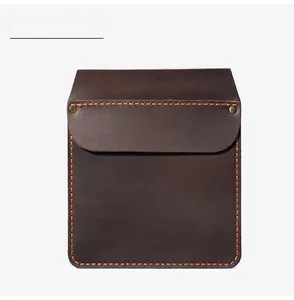 Close-up of coffee brown leather pocket holster with orange stitching and brass rivets