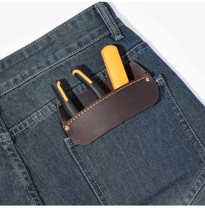 Detail of genuine brown leather EDC pocket organizer tucked into a denim back pocket
