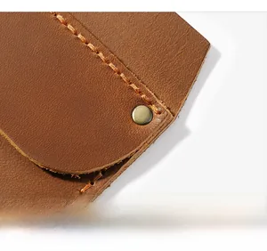 Detail of genuine brown leather pocket organizer with metal snap and manual stitching