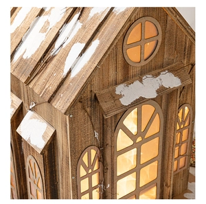 Détail macro de maison de Noël en bois avec neige artificielle et lueur LED chaleureuse