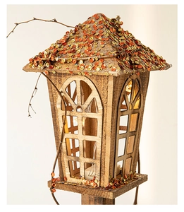 Gros plan d'une maison de Noël en bois avec paillettes et guirlande lumineuse LED interne