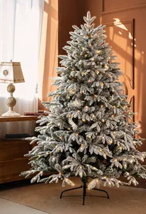 Close-up of Nordic flocked Christmas tree with warm LED lights and snowy branch texture