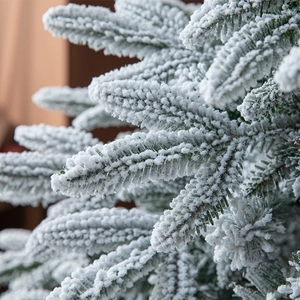 Lussuoso albero di Natale artificiale innevato con fitti aghi di pino coperti di neve