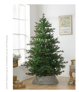 Lush green artificial Christmas tree with a decorative grey woven tree skirt base