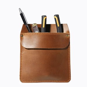 Brown handmade leather tool pouch with rivets and tools on a clean white background
