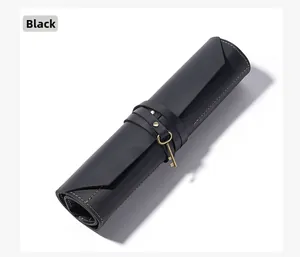 Detail of black leather roll pouch with yellow stitching and retro key charm closure