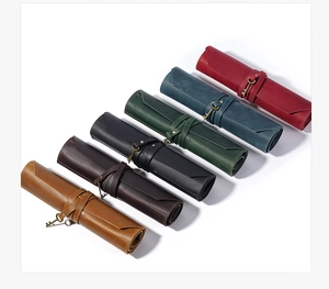 Detail view of colorful vintage leather roll-up pencil cases with retro key pendants