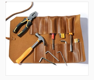 Detail view of brown leather tool roll showing slots for wrenches and screwdrivers