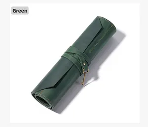 Detail of green leather tool roll bag with yellow stitching and vintage key charm