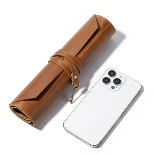 Vintage brown leather roll-up pencil case with strap and key charm, shown with smartphone