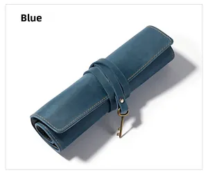Dettaglio dell'astuccio in pelle blu con cuciture gialle e ciondolo a chiave in ottone