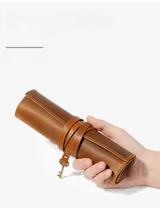 Detail of vintage crazy horse leather pencil roll with tie closure and key charm