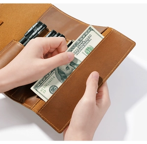 Detail view of crazy horse leather pencil roll showing pen slots and cash compartments