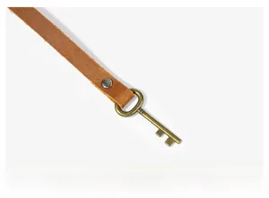 Detailed close-up of brown crazy horse leather texture and bronze rivet on pen case
