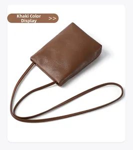 Close-up of khaki genuine leather phone bag with pebbled texture and matching strap