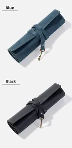 Detail of vintage blue and black leather roll pencil cases with key charm closures