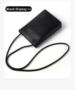 Detailed shot of black litchi grain leather texture on a minimalist mobile phone bag