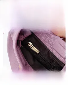Macro shot of the purple leather phone bag interior with golden metal zipper and brown lining
