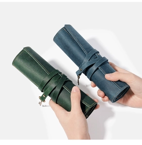 Detail of vintage genuine leather roll-up pencil cases in dark green and grey-blue finishes
