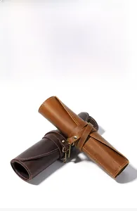 Detailed macro of vintage crazy horse leather pencil roll showing texture and stitching