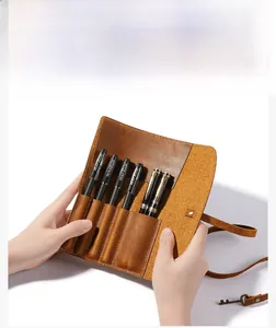 Macro detail of crazy horse leather pencil roll showing multi-slot storage and pens