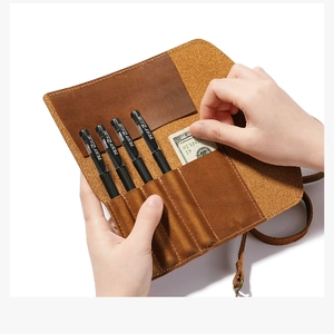 Detail of vintage brown leather roll pencil case with four slots and a side money pocket