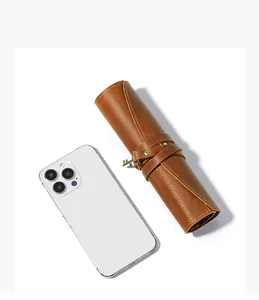 Brown vintage leather roll pencil case with key pendant shown next to a smartphone