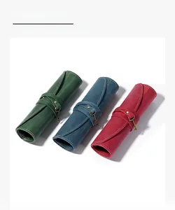 Detail of vintage crazy horse leather roll-up pencil cases with retro key pendants
