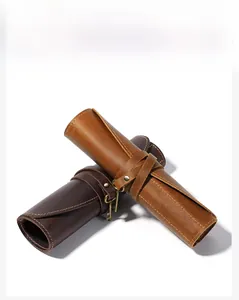 Detail of vintage cowhide leather roll pencil cases in brown and coffee with key closure