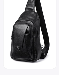 Detailansicht der schwarzen Leder-Brusttasche mit Metallschnalle und Reißverschluss