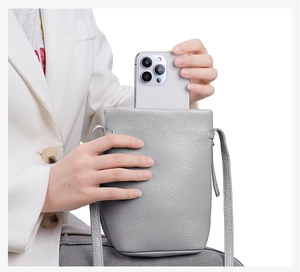 Detail einer grauen Handy-Umhängetasche aus Leder für große Smartphones mit Gurt