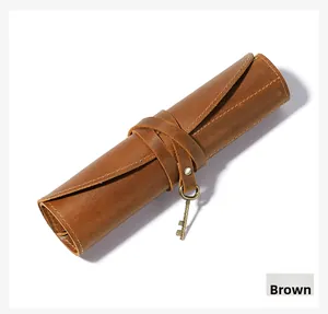 Macro detail of crazy horse leather pen roll with vintage key charm and stitching