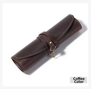 Detail of coffee brown crazy horse leather pen roll with vintage metal key charm