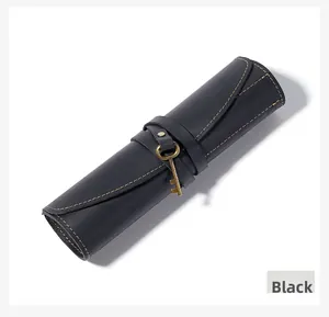 Detail of black crazy horse leather roll-up pencil case with retro bronze key closure