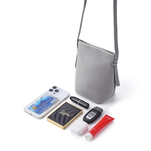 Graue Eimer-Tasche aus Leder mit Kieselmaserung und Alltagsgegenständen wie Handy