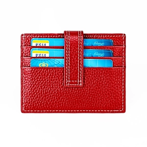 Macro view of bright red lychee texture leather card holder with contrast white stitching