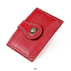 Detail of red pebbled leather wallet with contrast stitching and golden rose badge