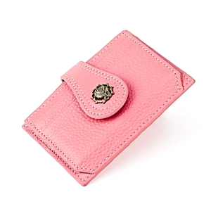 Detail of pink lychee grain leather wallet featuring a bronze rose buckle and card slots
