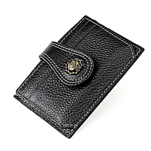 Close-up of black leather card holder with bronze rose emblem and white stitching