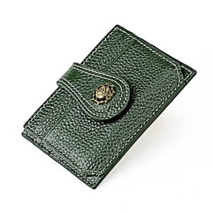 Detail of dark green pebble leather card holder with floral metal buckle and white stitching